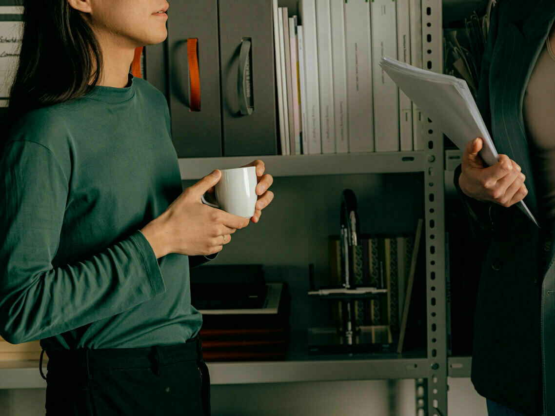 Building data visualization - Two people standing and talking in front of office shelves
